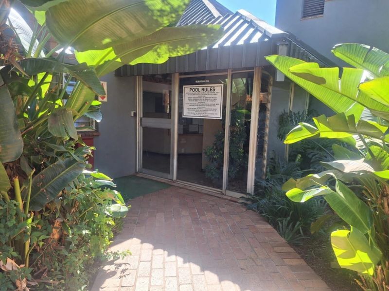 Entrance to the complex recreational area featuring a brick paved walkway and aluminium framed glass doors.