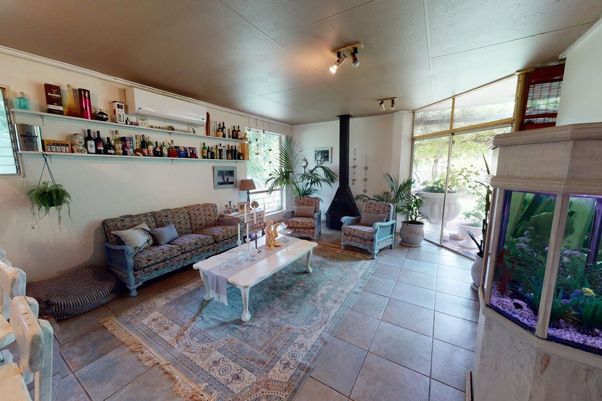 Spacious living room featuring tiled flooring, a freestanding fireplace, and large sliding glass doors providing natural light and access to the outdoor area.