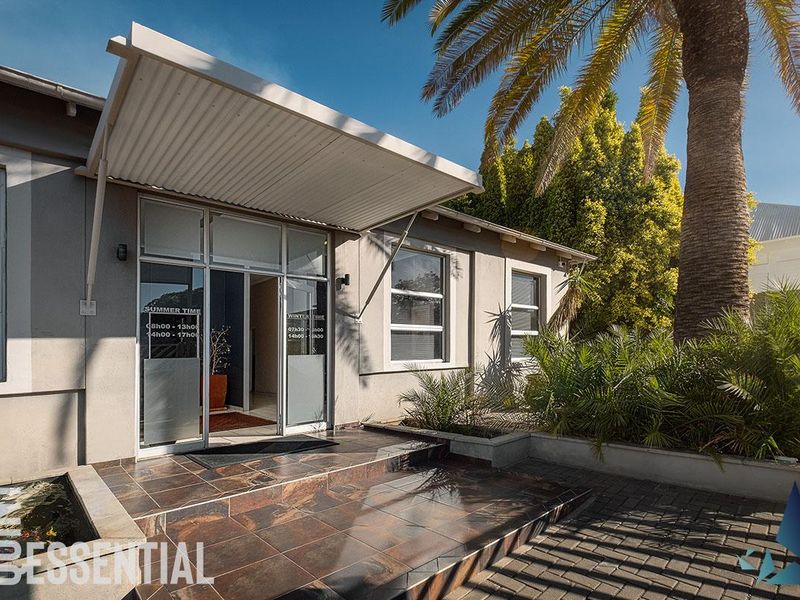 The front entrance of the office building features a covered canopy, tiled landing, and paved approach, presenting a professional and well-maintained facade.