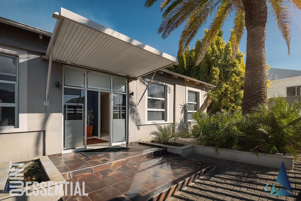 The front entrance of the office building features a covered canopy, tiled landing, and paved approach, presenting a professional and well-maintained facade.