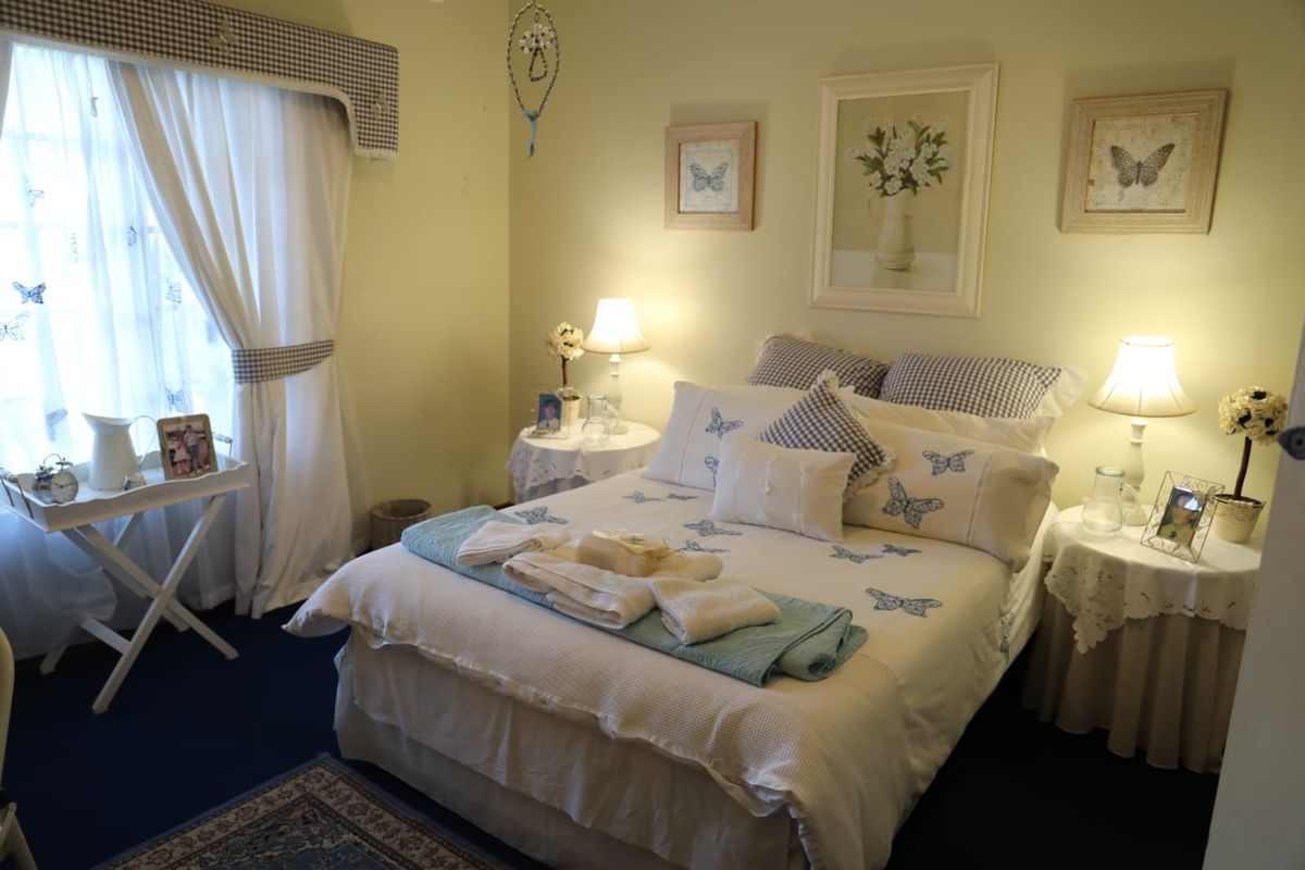 A cozy bedroom featuring carpeted flooring and a decorative curtain pelmet, providing a comfortable and functional sleeping space.