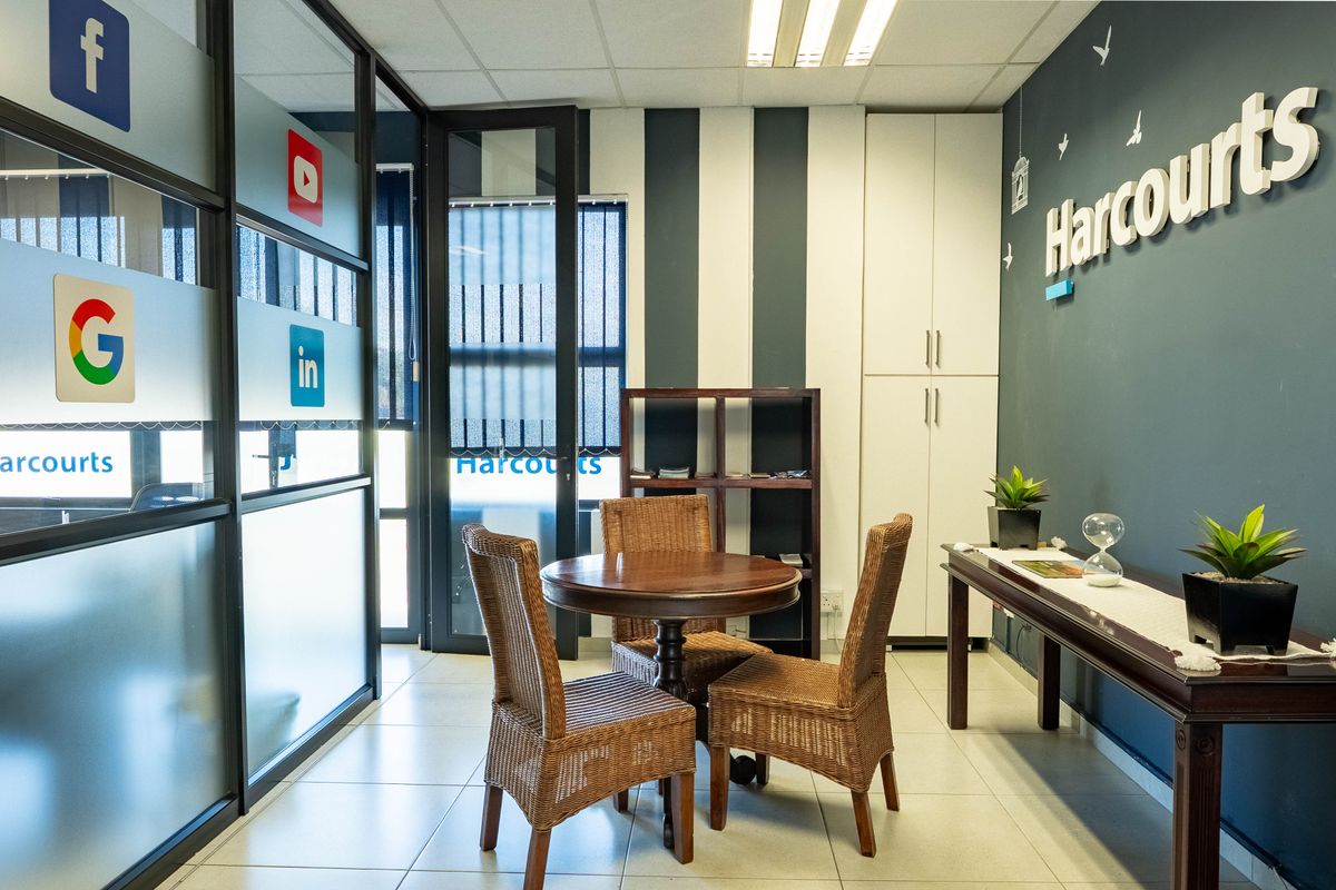 A professional office space featuring glass partitions, built-in storage cabinetry, tiled flooring, and modern accent wall detailing.