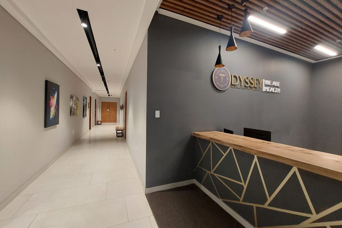 Modern commercial reception area featuring a custom reception desk, slatted timber ceiling details, recessed linear lighting, and professional signage in a clean, well-maintained space.