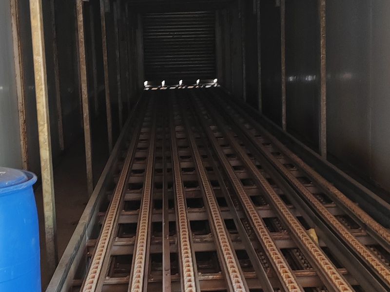 Industrial utility space featuring a fixed conveyor track system and overhead ventilation ducting, suitable for specialized manufacturing or logistics operations.