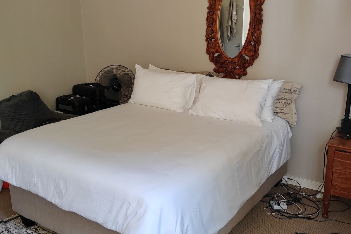 A standard bedroom featuring neutral wall tones and carpeted flooring, providing a functional and comfortable sleeping space.