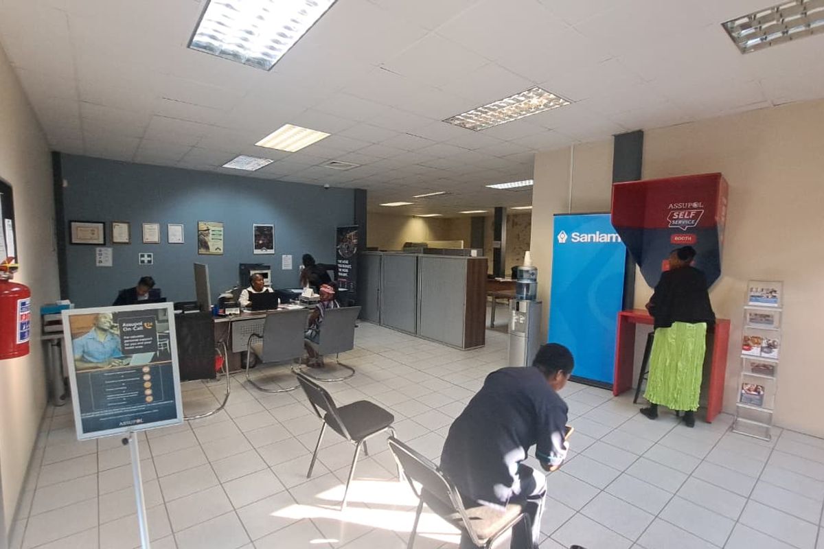 A functional office space featuring tiled flooring, recessed ceiling lighting, and partitioned work areas suitable for professional service operations.