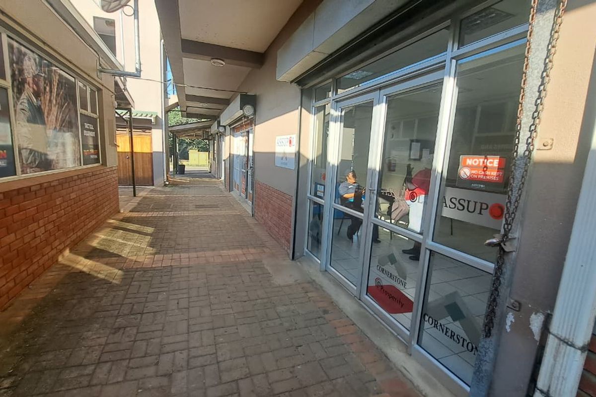 Exterior view of an office entrance featuring a paved walkway and aluminium shopfront facade.