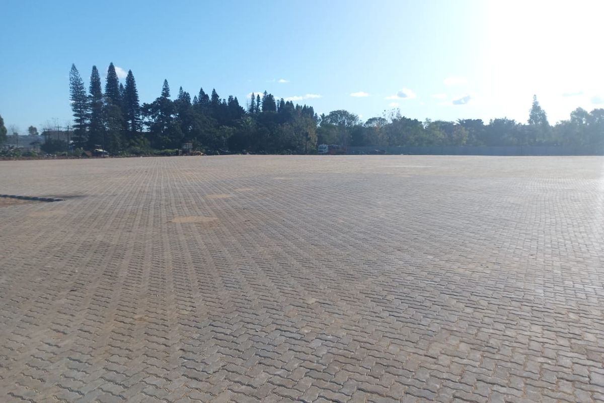 A large, open industrial yard featuring extensive interlocking paved surfacing, suitable for heavy-duty storage or logistics operations.