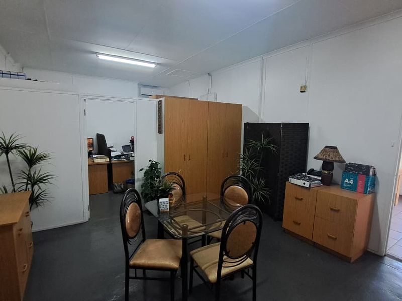 A functional office space featuring built-in cabinetry, tiled flooring, and overhead fluorescent lighting, providing a practical work environment.