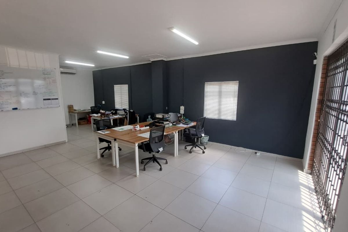 A functional office space featuring tiled flooring, air conditioning, and secure access, providing a practical environment for professional operations.