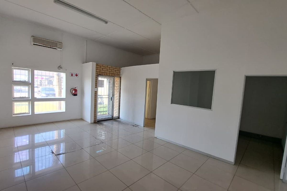 Open-plan industrial office space featuring tiled flooring, split-system air conditioning, and neutral white walls, suitable for a variety of commercial uses.