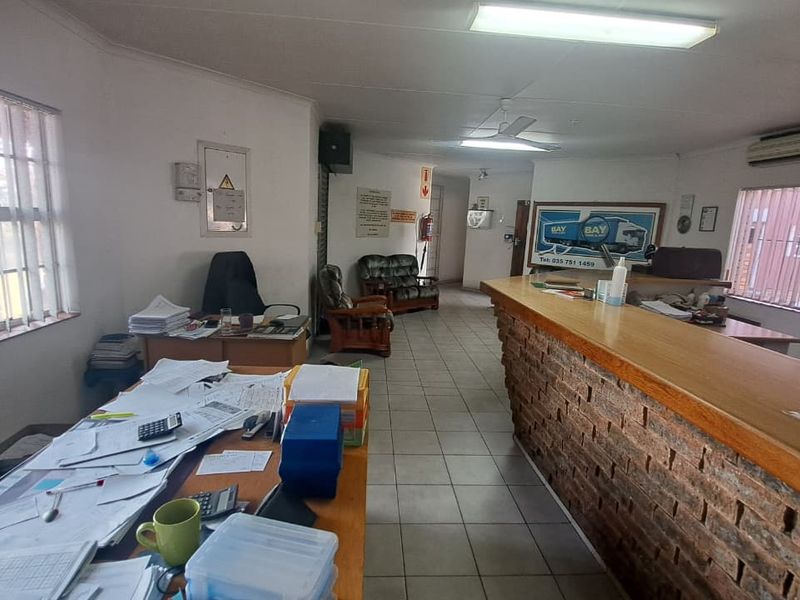 Functional industrial office space featuring a brick-faced reception counter, security window bars, and integrated climate control systems.