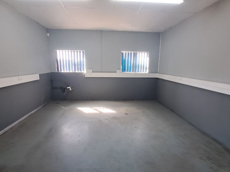 An empty industrial office space featuring concrete flooring, suspended ceiling, and perimeter electrical trunking, suitable for a variety of commercial or administrative uses.