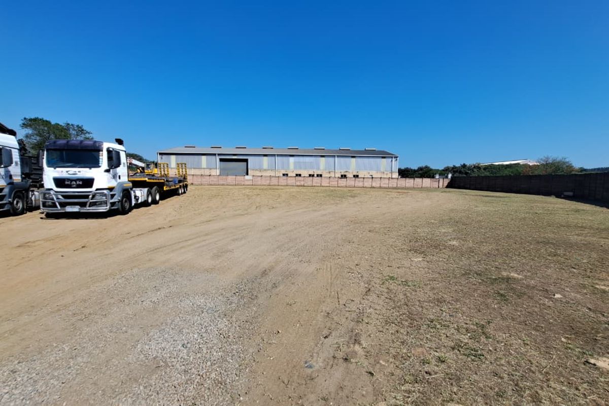 A spacious industrial yard area featuring a perimeter wall and ample open space for vehicle maneuvering or storage.