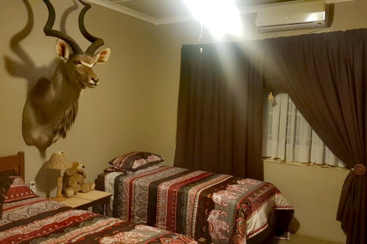 A bedroom featuring a wall-mounted split-system air conditioner and neutral wall finishes.