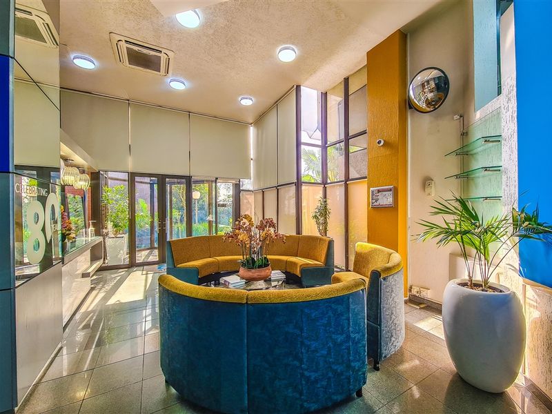A bright and welcoming office reception area featuring tiled flooring, floor-to-ceiling glass partitions, and integrated recessed lighting.
