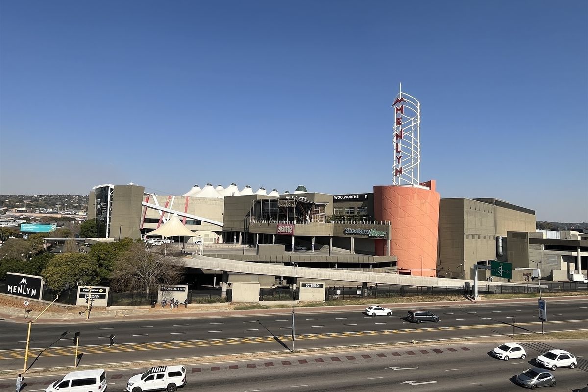 Aerial view of the Menlyn Park shopping centre complex, showcasing its large-scale commercial architecture, prominent signage, and surrounding road infrastructure.