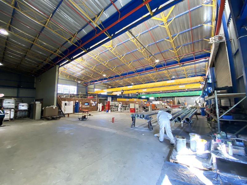 Spacious industrial warehouse facility featuring high ceilings, overhead crane infrastructure, and durable concrete flooring suitable for manufacturing or storage operations.