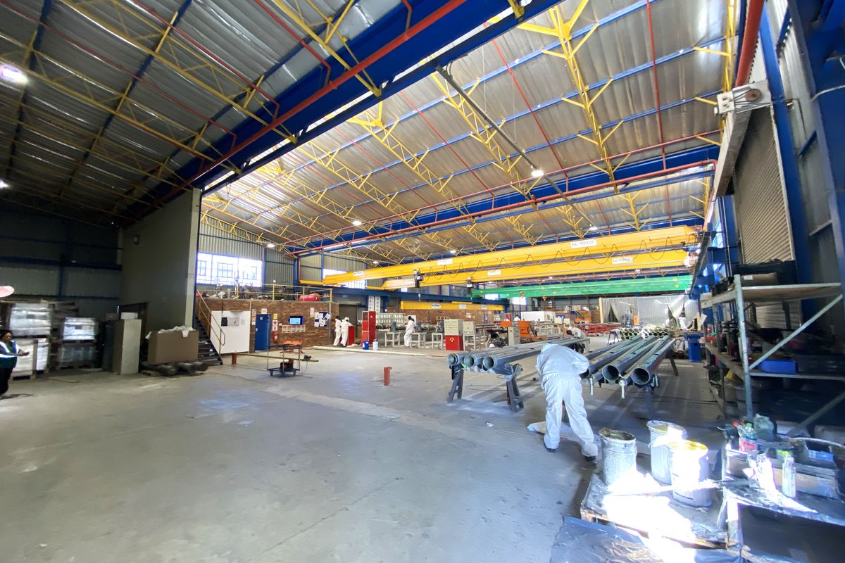 Spacious industrial warehouse facility featuring high ceilings, overhead crane infrastructure, and durable concrete flooring suitable for manufacturing or storage operations.