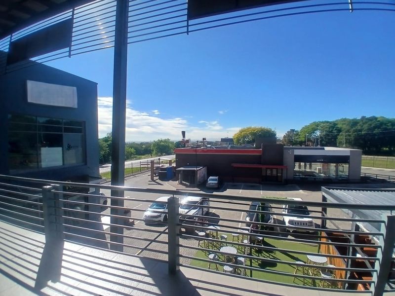 Elevated balcony area with metal railings overlooking the office park parking lot and surrounding commercial area.