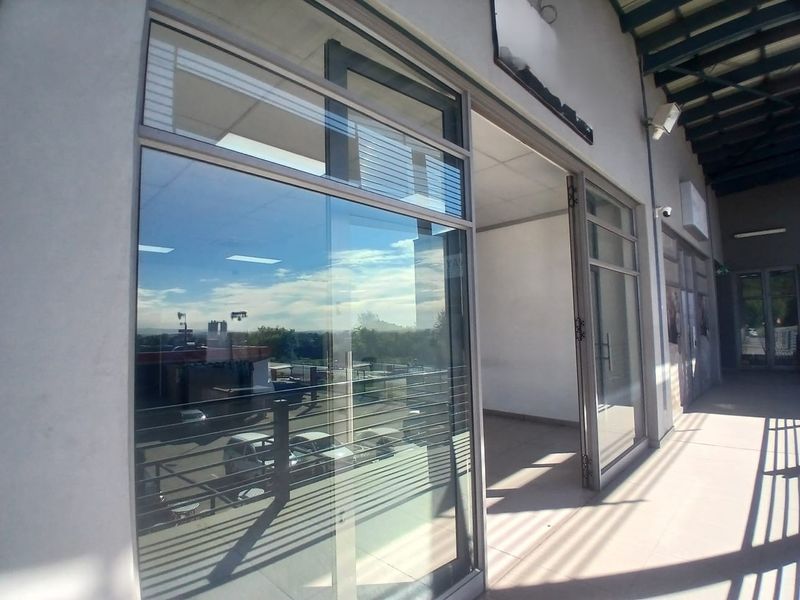 Exterior view of a modern office storefront featuring large glass windows, aluminum framing, and a covered walkway entrance.