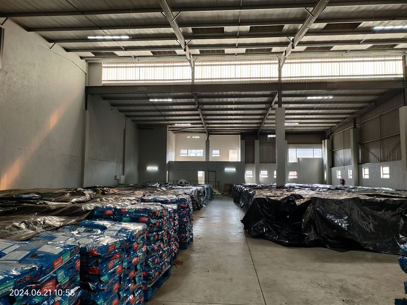 Spacious industrial warehouse featuring high ceilings, concrete flooring, and ample natural light through clerestory windows, suitable for storage or manufacturing operations.