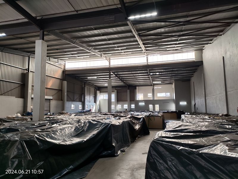 Spacious industrial warehouse featuring a high-clearance steel portal frame, concrete flooring, and ample natural light through clerestory windows.