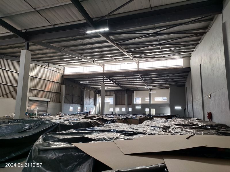 Spacious industrial warehouse featuring a high-clearance steel portal frame, concrete flooring, and ample natural light through clerestory windows.