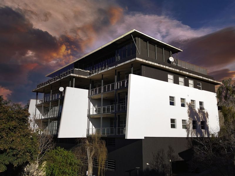 A modern multi-story office building featuring a striking black and white facade with integrated balconies and large windows.