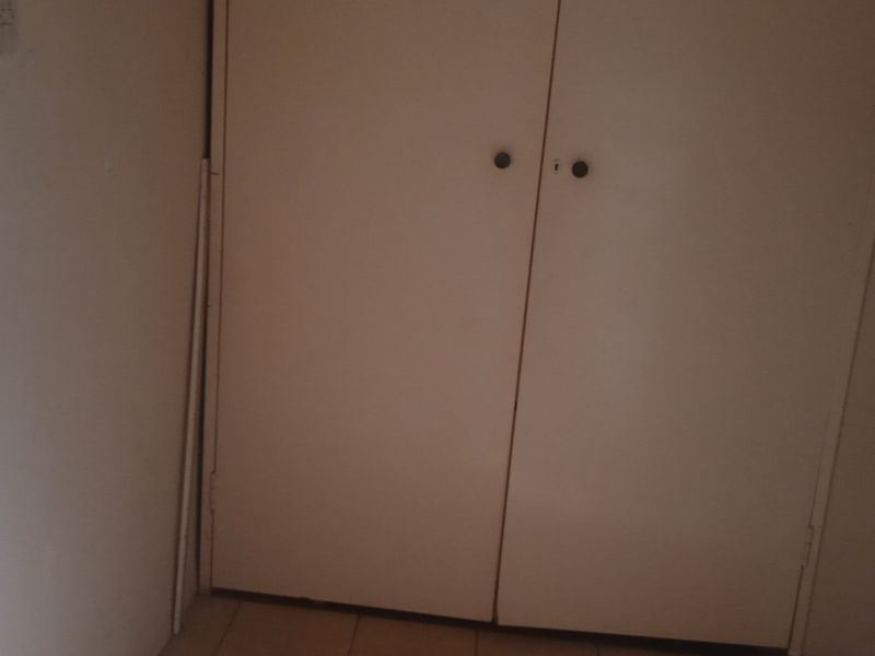 A hallway area featuring built-in cupboards with white doors.