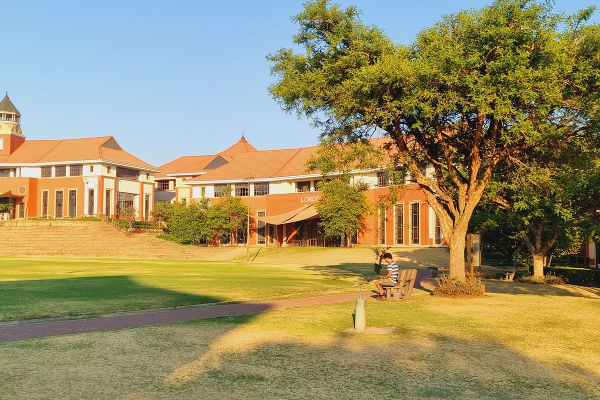 A view of the office complex exterior featuring brick architecture, tiled roofs, and landscaped green spaces with paved walkways.