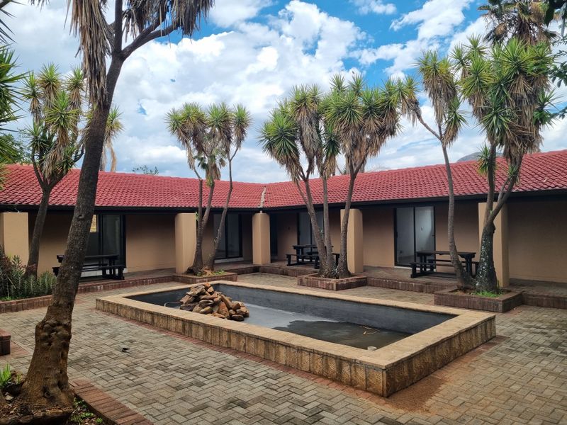A central courtyard area featuring a paved patio, built-in water feature, and access to multiple guest units via sliding glass doors.