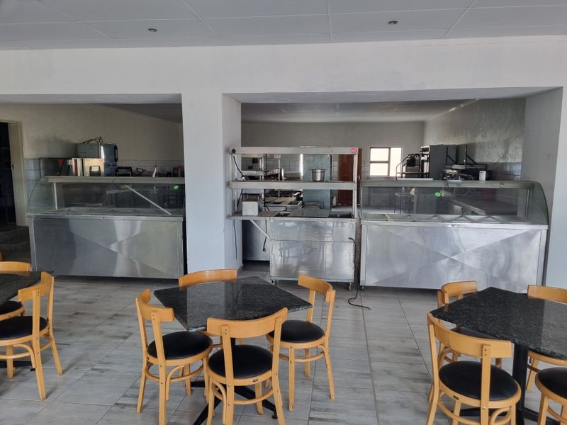 Commercial kitchen area featuring stainless steel food display counters and tiled flooring, suitable for guest house catering operations.