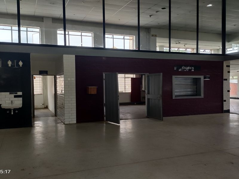 Spacious industrial open-plan area featuring high ceilings, internal glass partitioning, a service hatch, and dedicated washroom access.