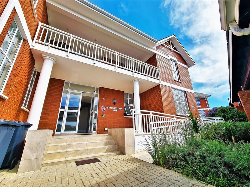 Front elevation of a professional office building featuring a brick facade, covered balcony, accessible ramp, and a welcoming glass entrance.