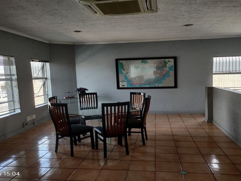 Open plan office or dining area featuring tiled flooring, recessed ceiling lighting, and a ceiling-mounted air conditioning unit.