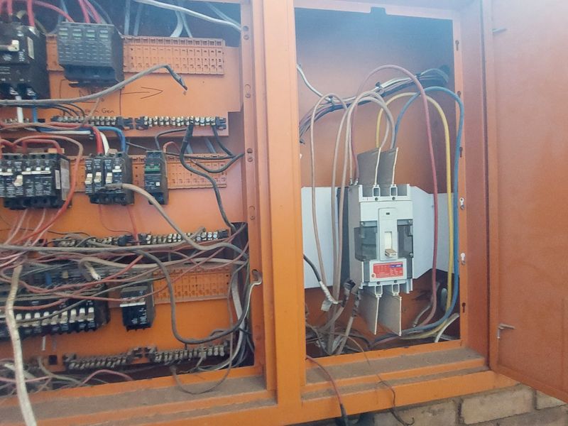 Industrial electrical distribution board with exposed wiring and circuit breakers, requiring professional inspection and maintenance for safety compliance.