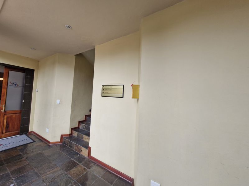 Commercial building entrance foyer featuring tiled flooring, a staircase leading to upper levels, and wall-mounted directory signage.