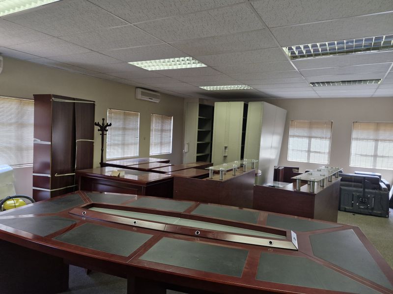 Spacious commercial office area featuring a suspended ceiling, recessed lighting, split-system air conditioning, and multiple windows fitted with venetian blinds.