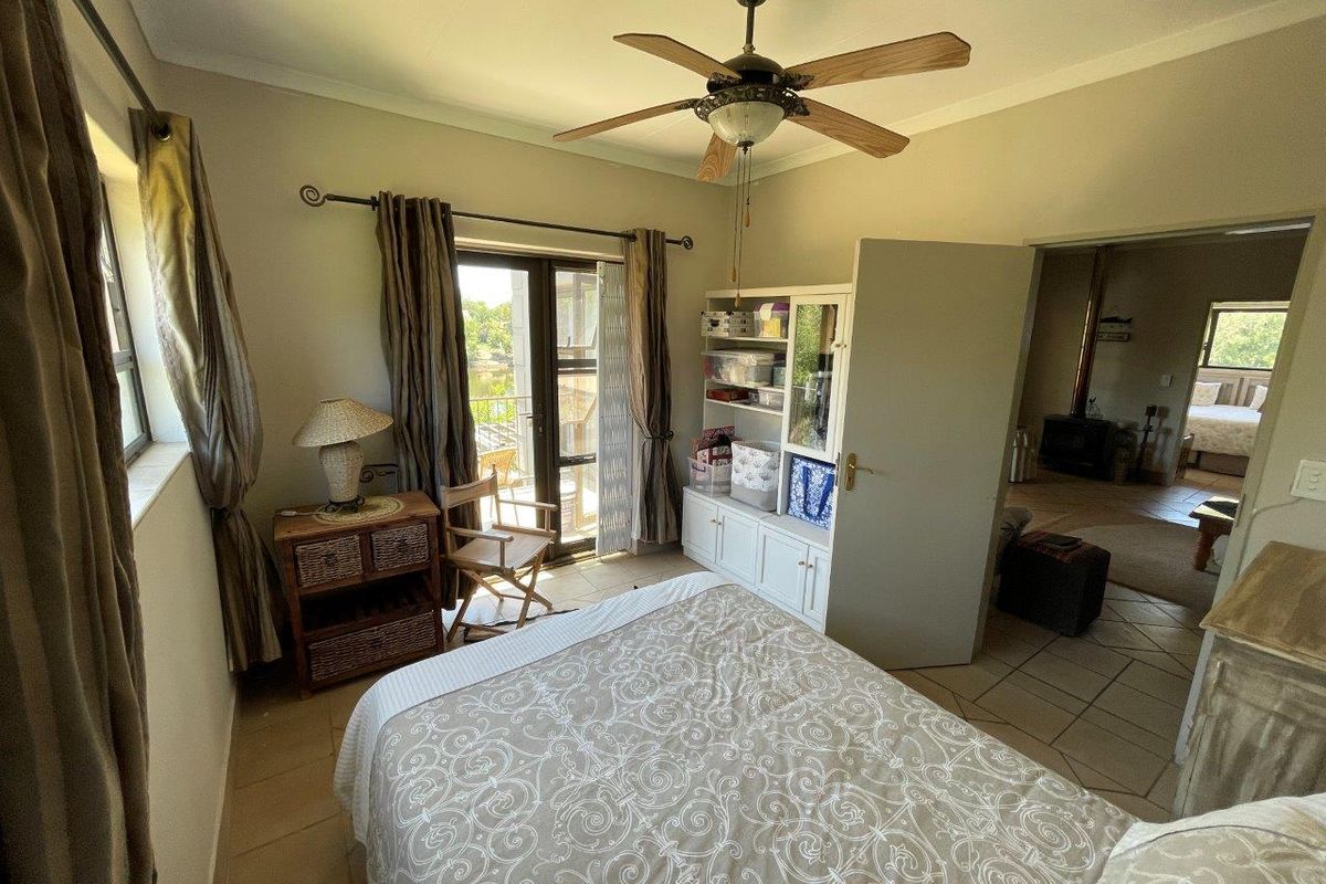 A bedroom featuring tiled flooring, a ceiling fan, and a glass sliding door providing access to an outdoor area.