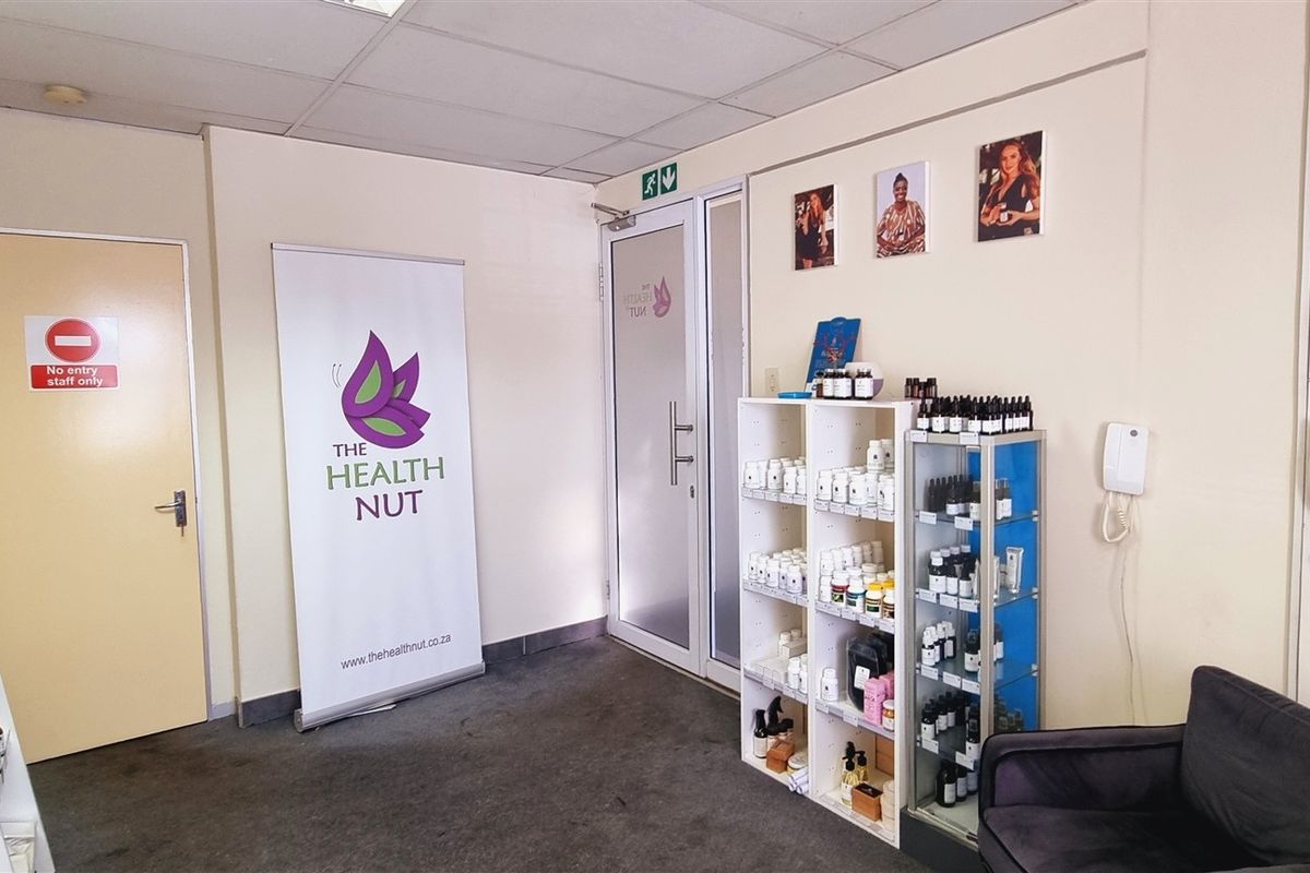 A functional office reception or retail space featuring a suspended ceiling, glass entry door, and wall-mounted communication systems.