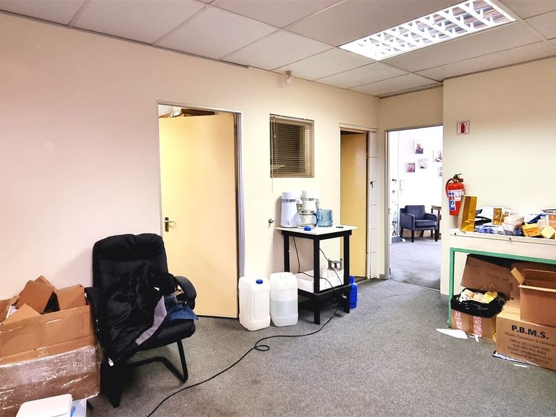 A functional office space featuring a suspended ceiling with recessed lighting and carpeted flooring, providing a practical work environment.