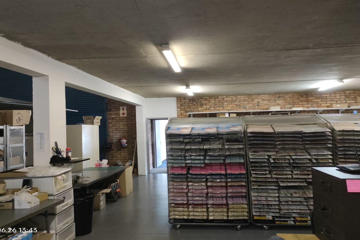 Industrial utility or storage space featuring exposed brick walls, concrete ceiling, and functional overhead fluorescent lighting.