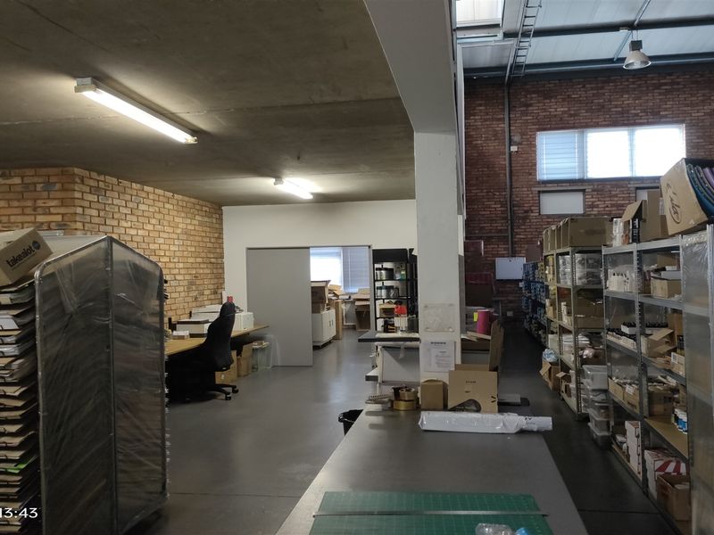 Industrial utility and storage space featuring exposed brick walls, concrete ceilings, and high-level skylights, suitable for warehouse or workshop operations.