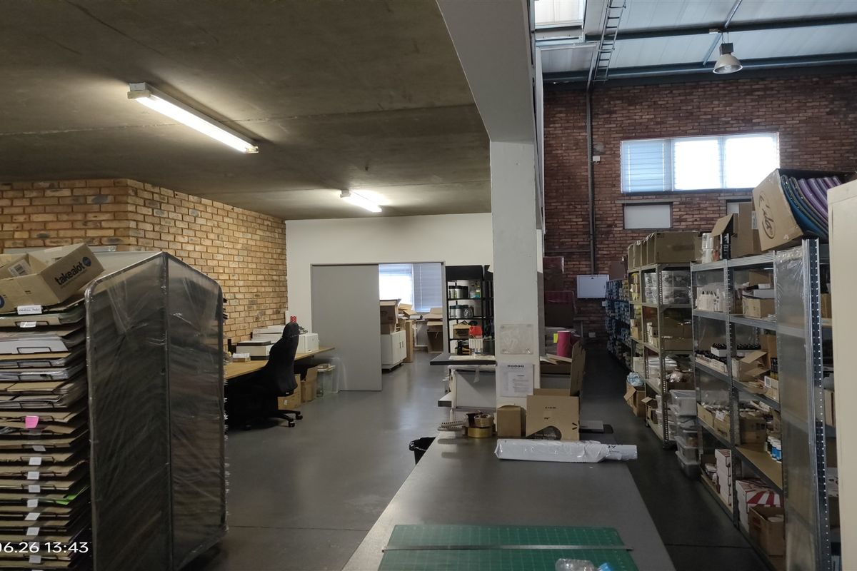 Industrial utility and storage space featuring exposed brick walls, concrete ceilings, and high-level skylights, suitable for warehouse or workshop operations.