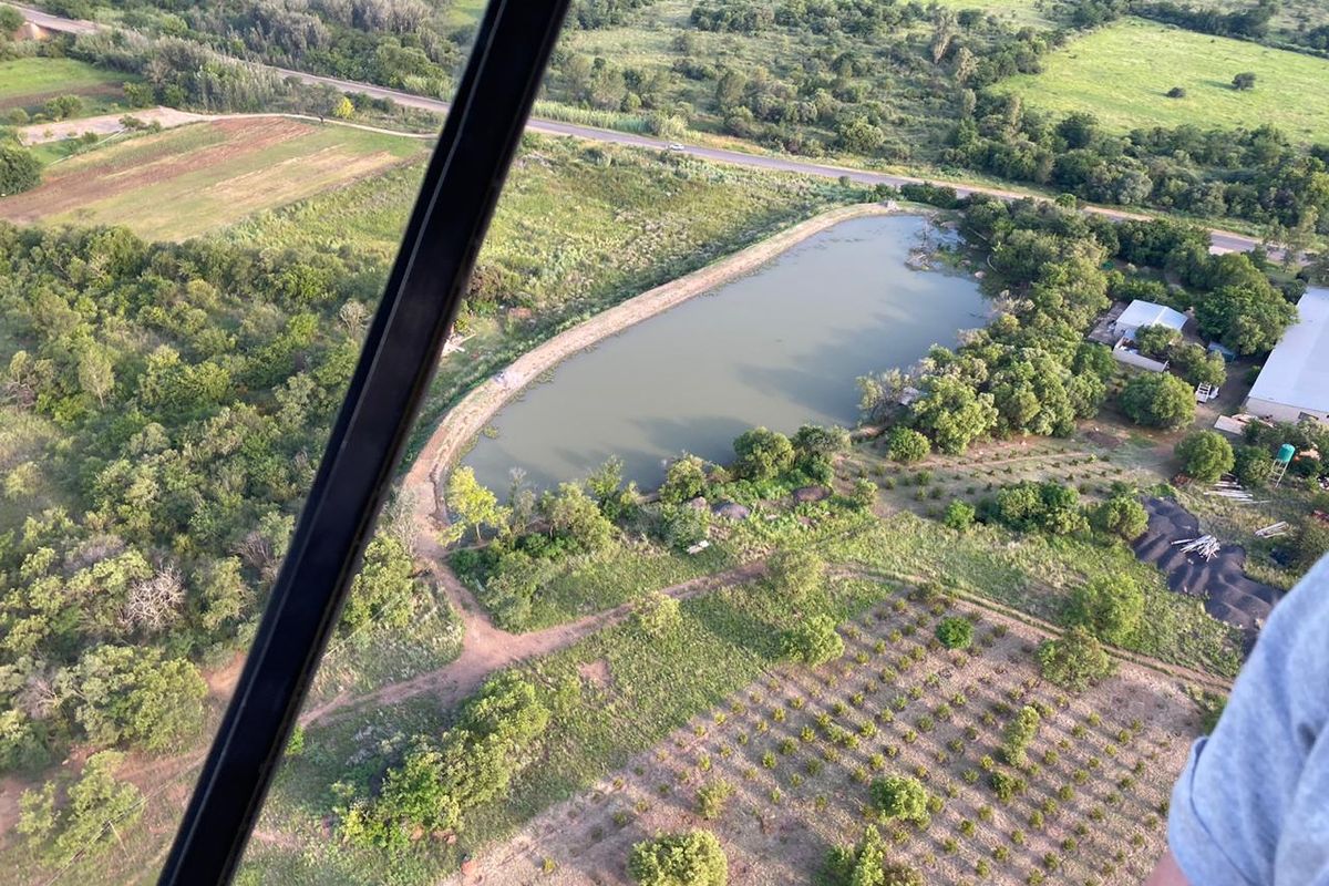 Aerial view of the farm property featuring a large dam, established orchard, and surrounding rural landscape.
