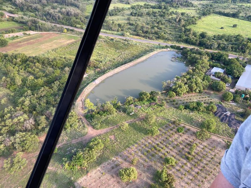 Aerial view of the farm property featuring a large dam, established orchard, and surrounding rural landscape.