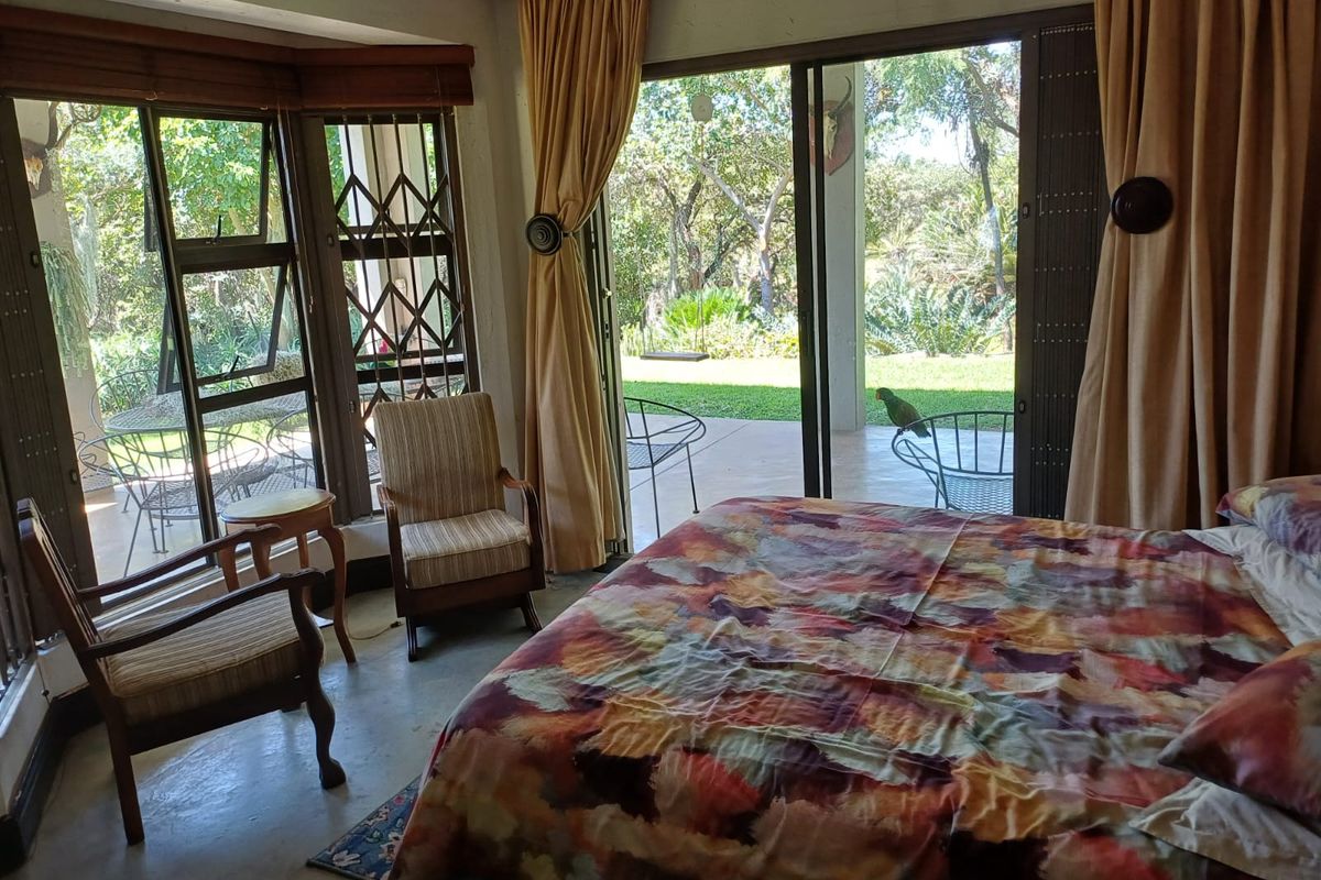 Spacious bedroom featuring concrete flooring and large sliding glass doors that provide direct access to the garden patio.