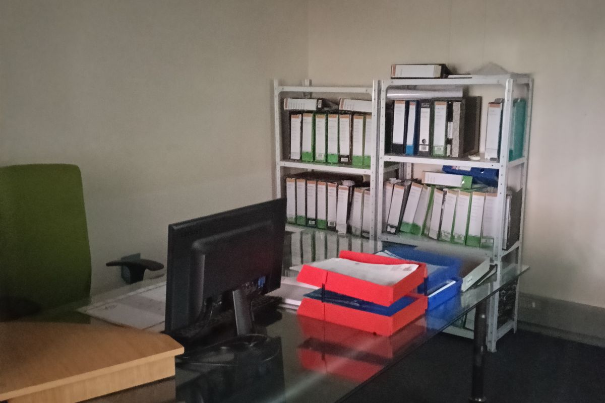 A functional office space featuring carpeted flooring, coving, and a wall-mounted split-system air conditioning unit.