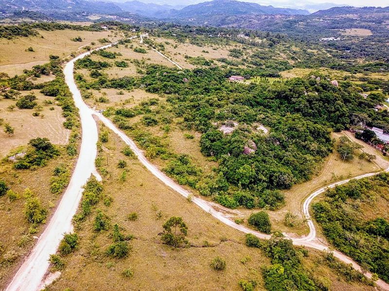 An aerial view of the small holding property showcasing the expansive natural landscape, indigenous vegetation, rock formations, and gravel access roads.
